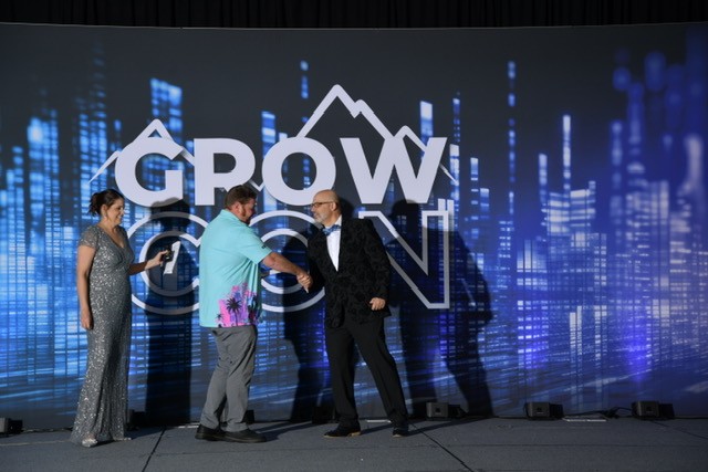 Trevor Brandol accepting an award on stage at GrowCon